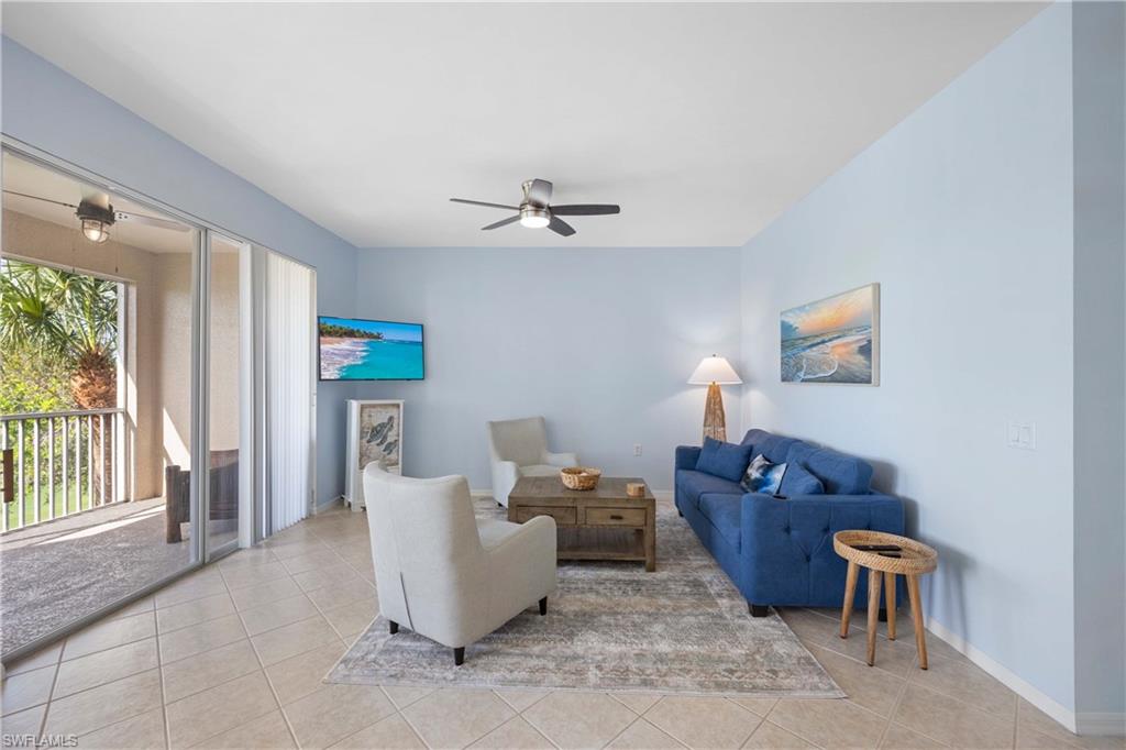 Living room with light tile patterned floors and ceiling fan