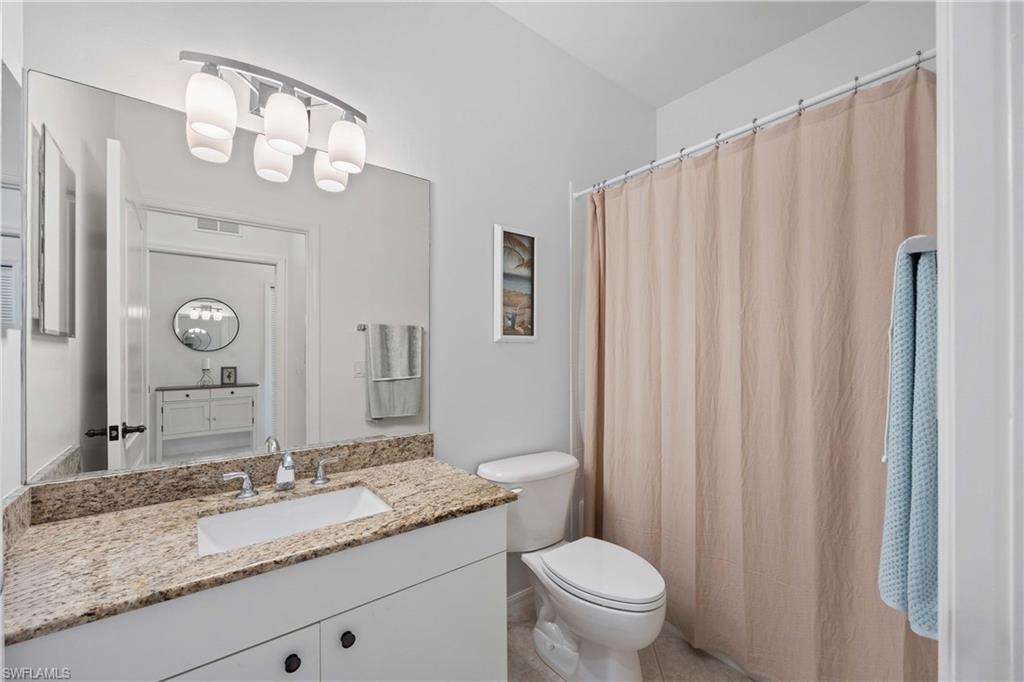 Bathroom with tile patterned floors, vanity, and toilet