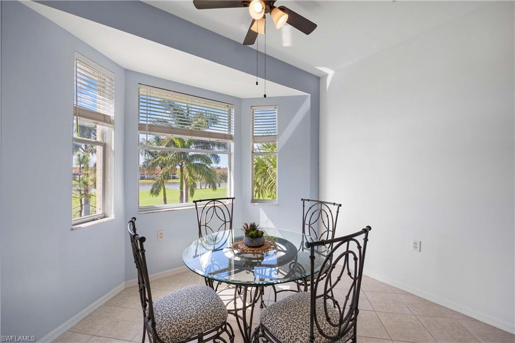 Dining area with ceiling fan, light tile patterned floors, and a healthy amount of sunlight