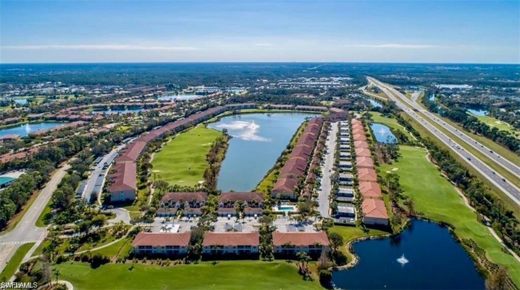 Birds eye view of property with a water view
