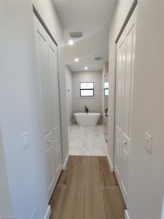 Hall with light wood finished floors and baseboards
