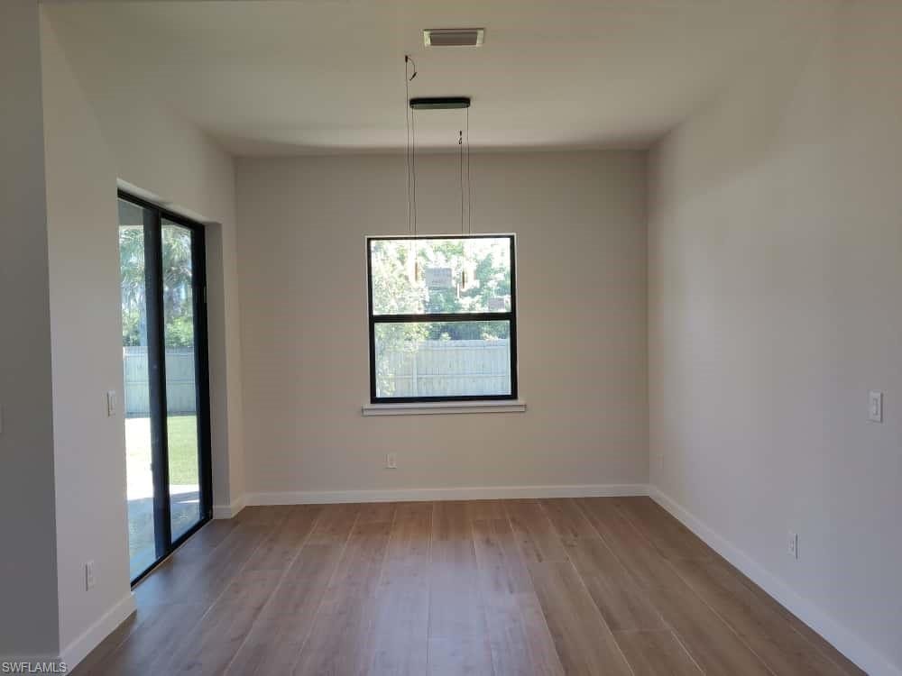 Unfurnished dining area featuring light wood-style flooring and baseboards
