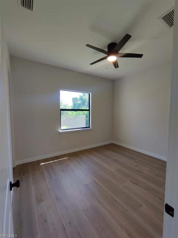 Empty room with light wood-style floors and ceiling fan