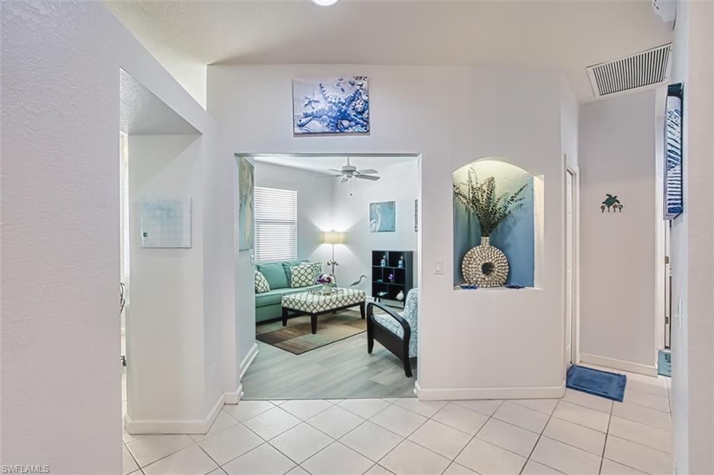 Corridor with light tile patterned floors and baseboards