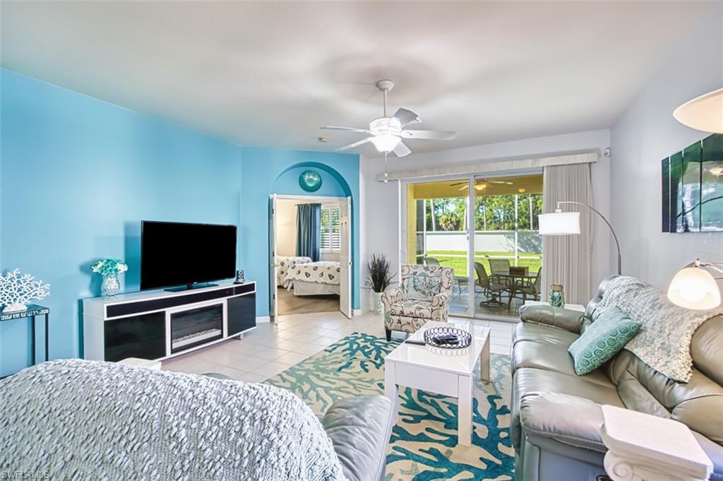 Living room with tile patterned flooring and a ceiling fan