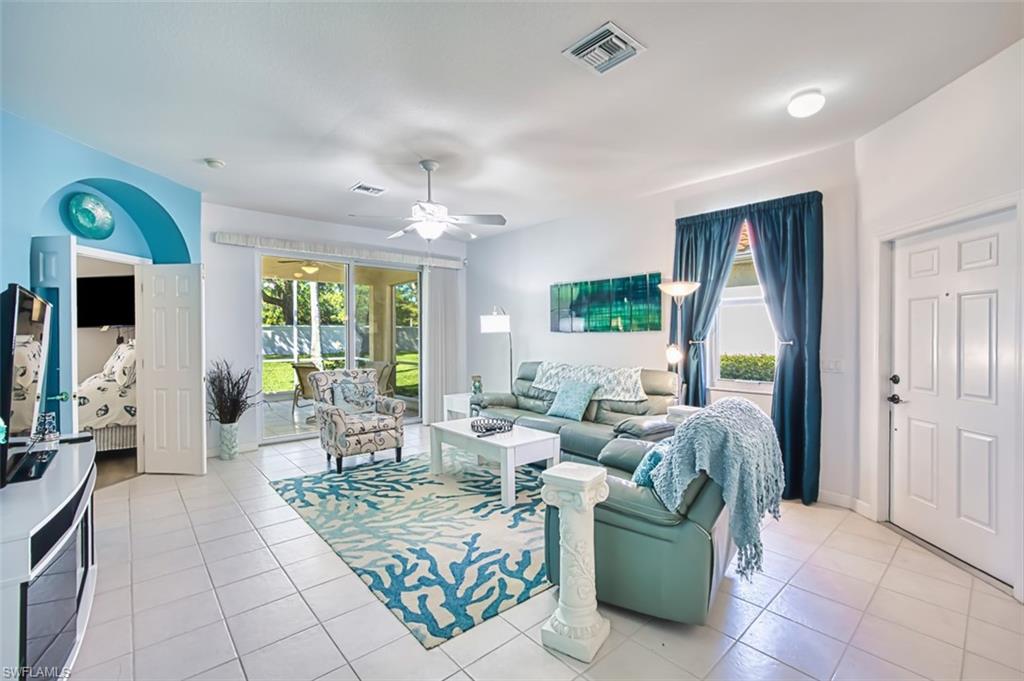 Living room featuring light tile patterned floors and a ceiling fan