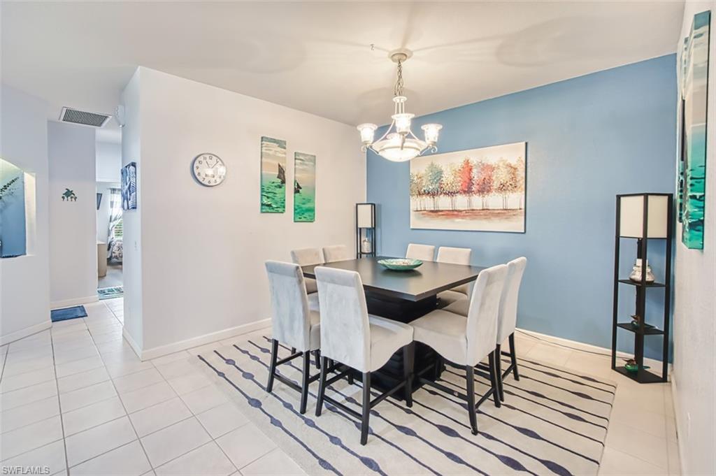 Dining space featuring light tile patterned flooring and a chandelier
