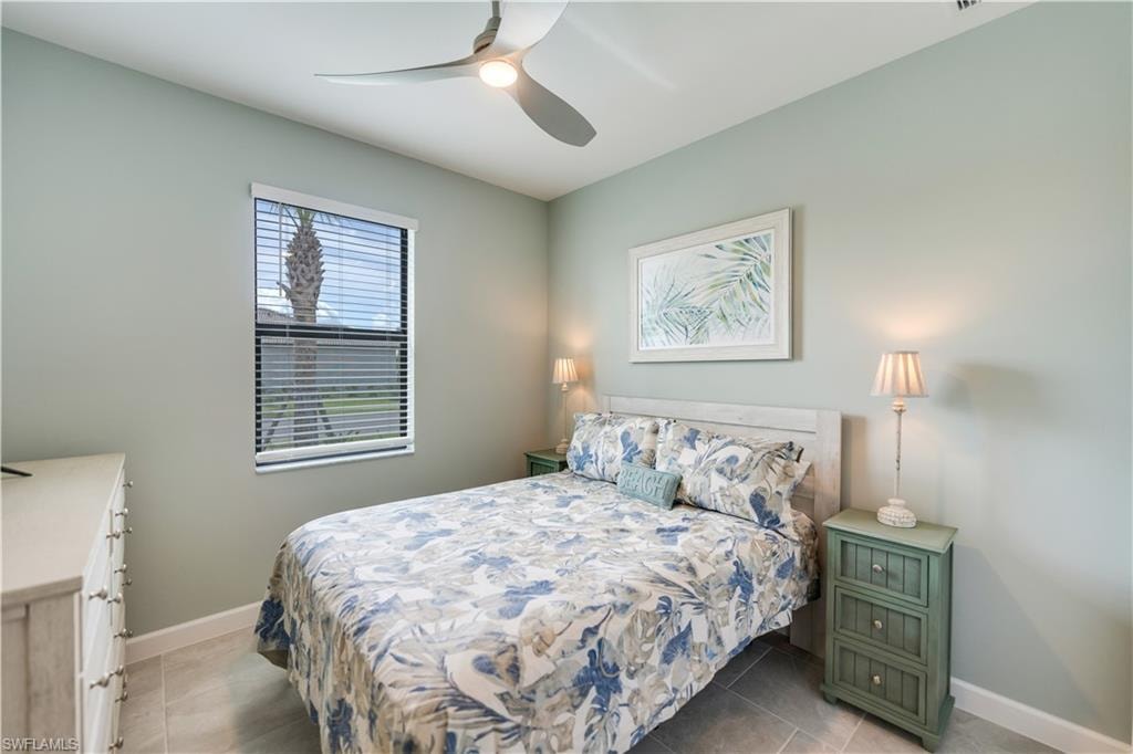 Tiled bedroom featuring ceiling fan