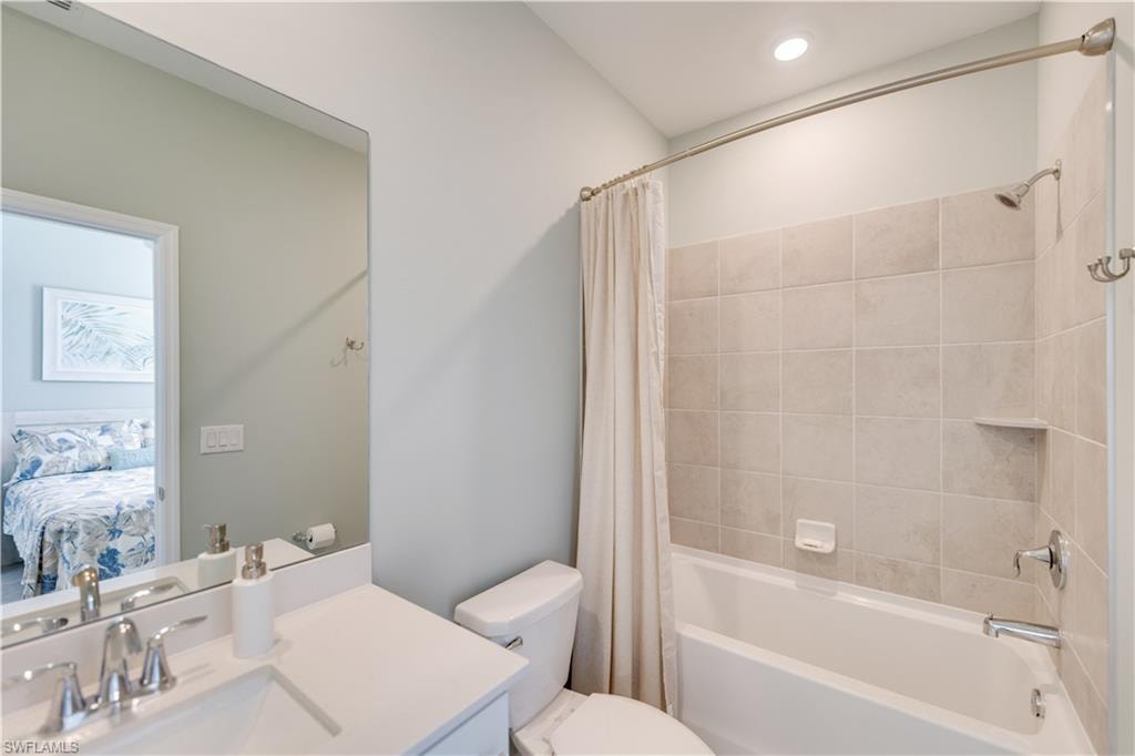 Full bathroom with vanity, toilet, and shower / bath combination with curtain