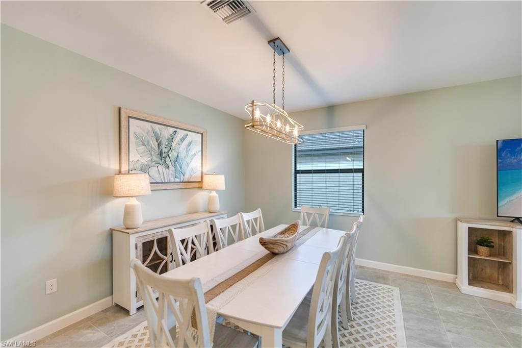 Dining area with an inviting chandelier and light tile patterned floors