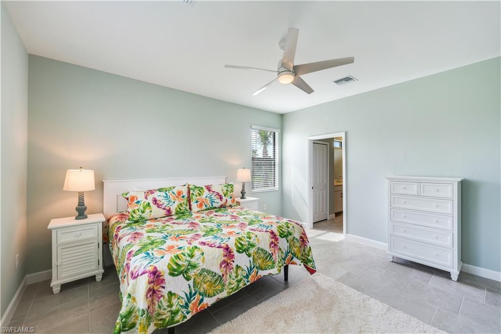 Tiled bedroom featuring ceiling fan