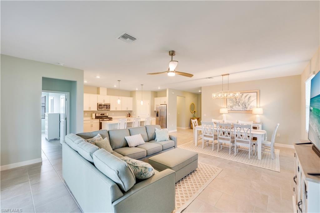 Living room featuring light tile patterned floors and ceiling fan