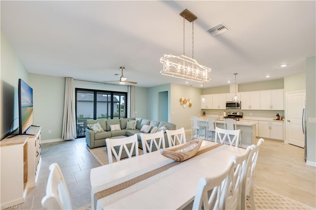 Dining space with light tile patterned floors and ceiling fan