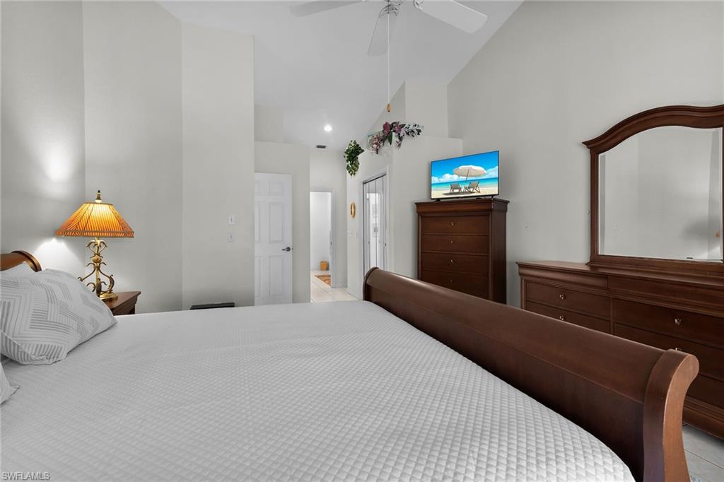 Bedroom with high vaulted ceiling, a closet, and ceiling fan