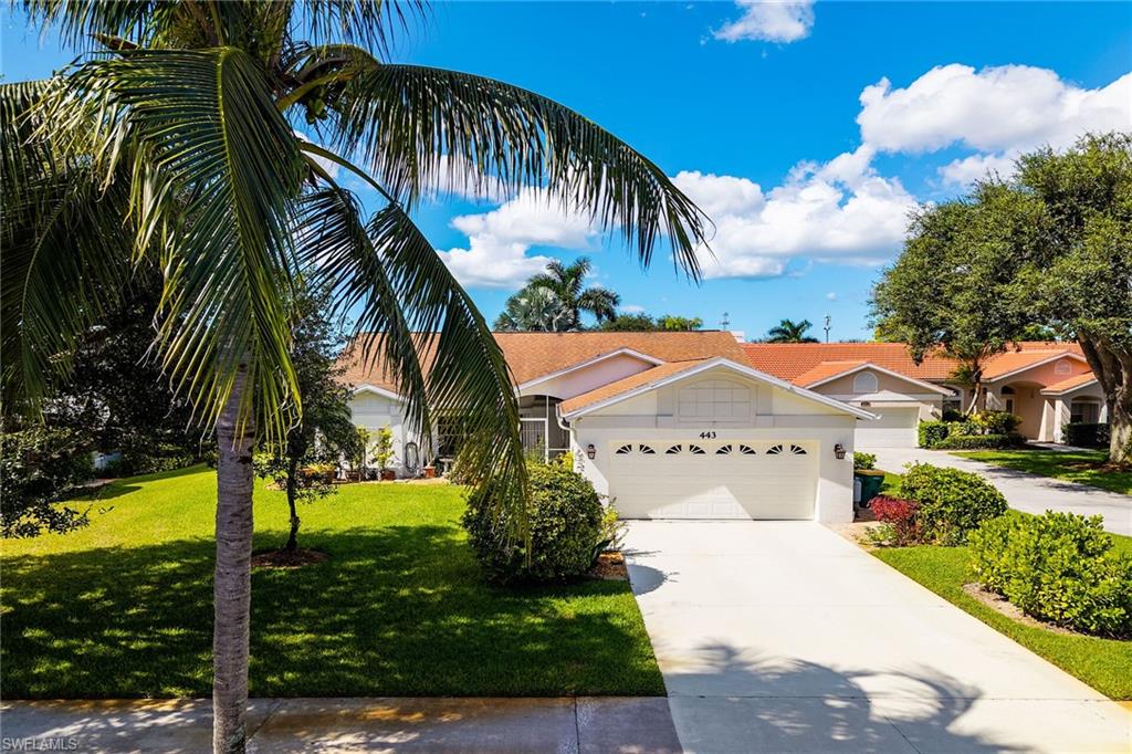 View of front of house featuring concrete driveway, a front yard, stucco siding, and a garage