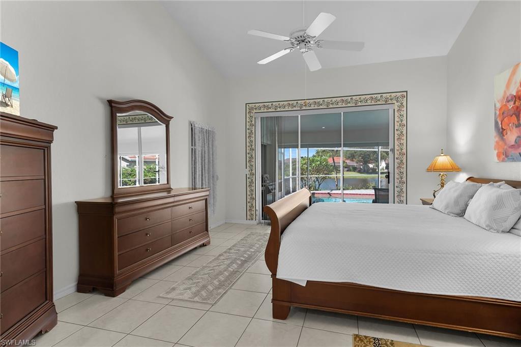 Bedroom with access to outside, multiple windows, ceiling fan, light tile patterned floors, and lofted ceiling