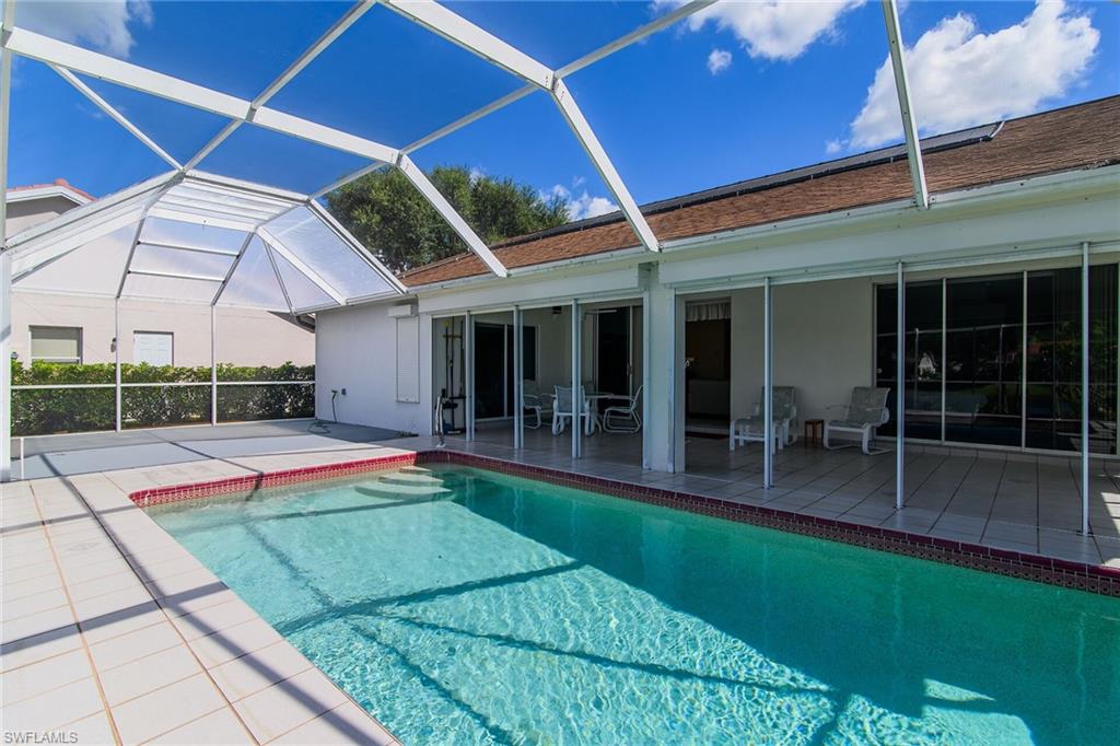 Swimming pool with glass enclosure, a sunroom, and a patio area