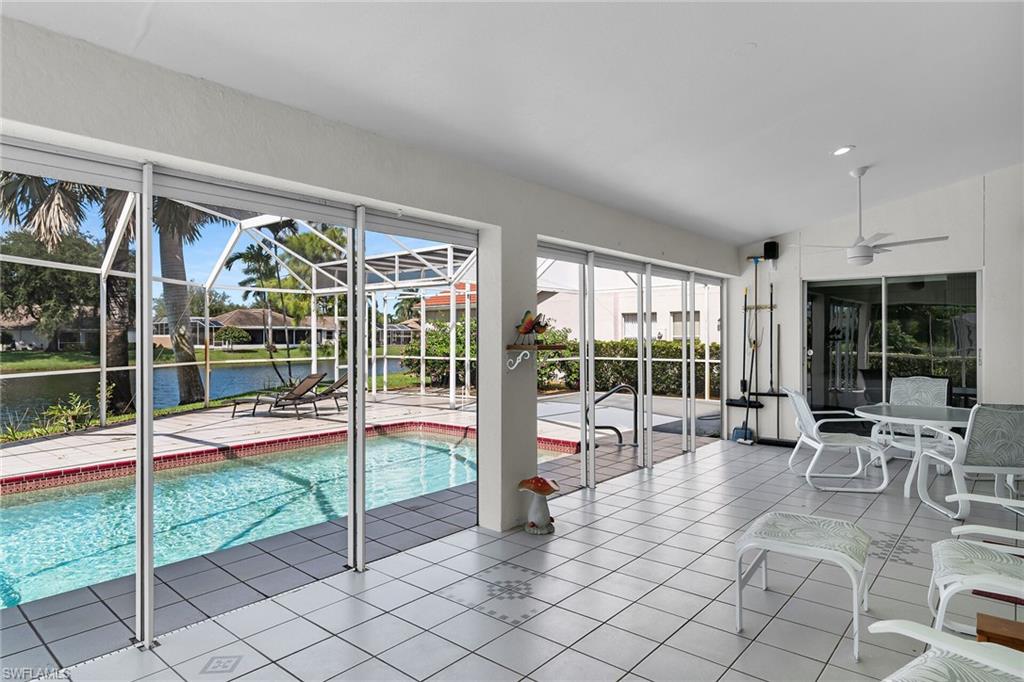 Swimming pool featuring a sunroom, a water view, and ceiling fan
