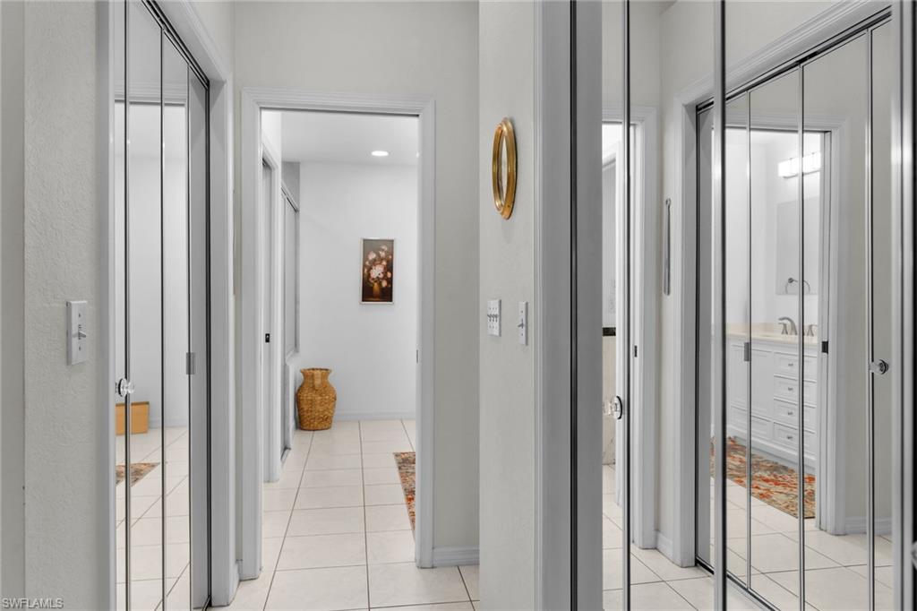 Corridor with light tile patterned flooring and baseboards