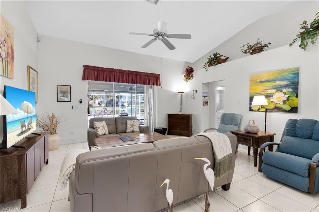 Living area featuring light tile patterned floors, a ceiling fan, and high vaulted ceiling
