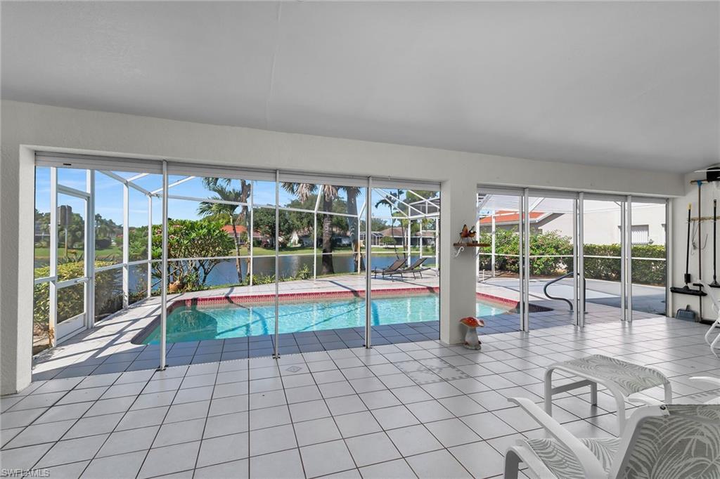 Outdoor pool with a sunroom and a water view
