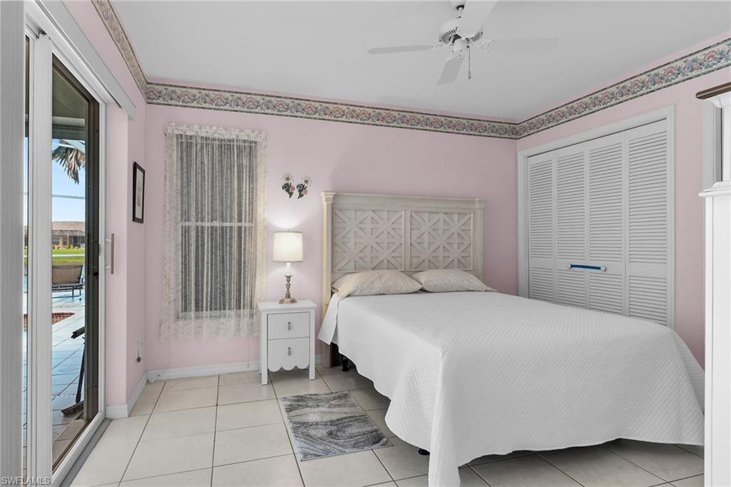 Bedroom with access to exterior, light tile patterned floors, a ceiling fan, and a closet