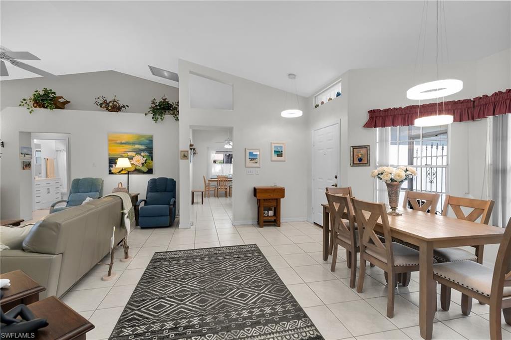 Dining room featuring a ceiling fan, light tile patterned floors, healthy amount of natural light, and high vaulted ceiling