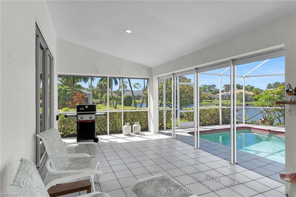 Unfurnished sunroom with lofted ceiling and a water view