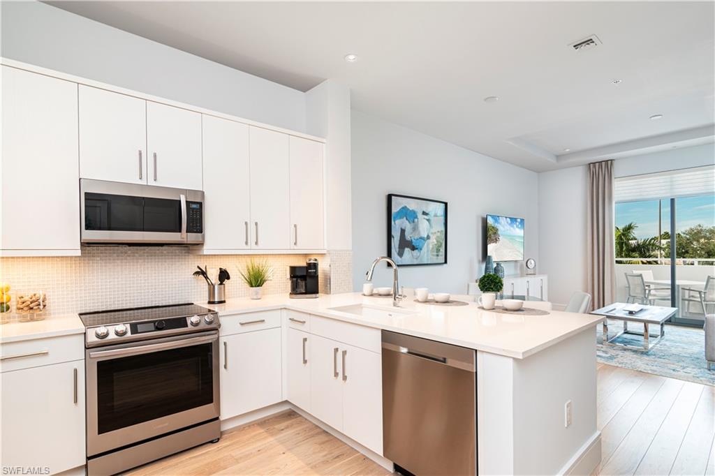 Kitchen with barstool additional eating area at island, facing sunset view balcony