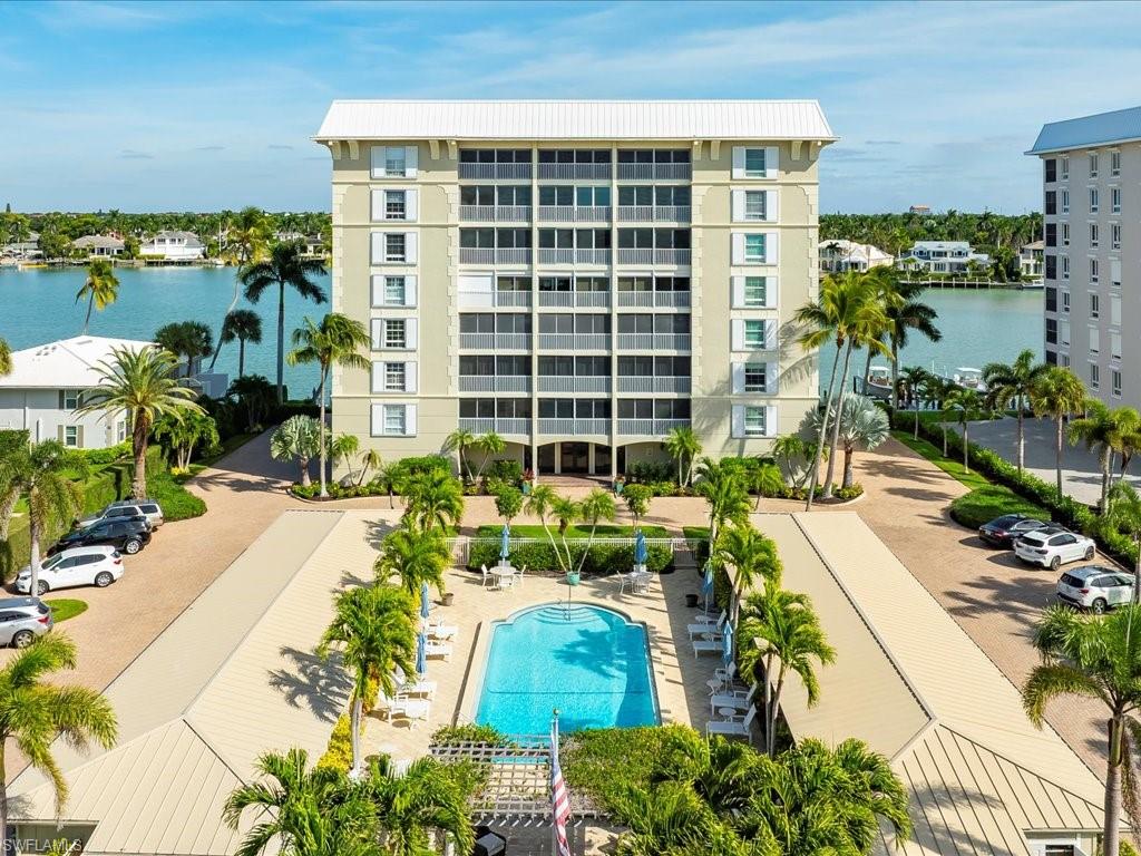 View of apartment building / complex with a water view and a community pool