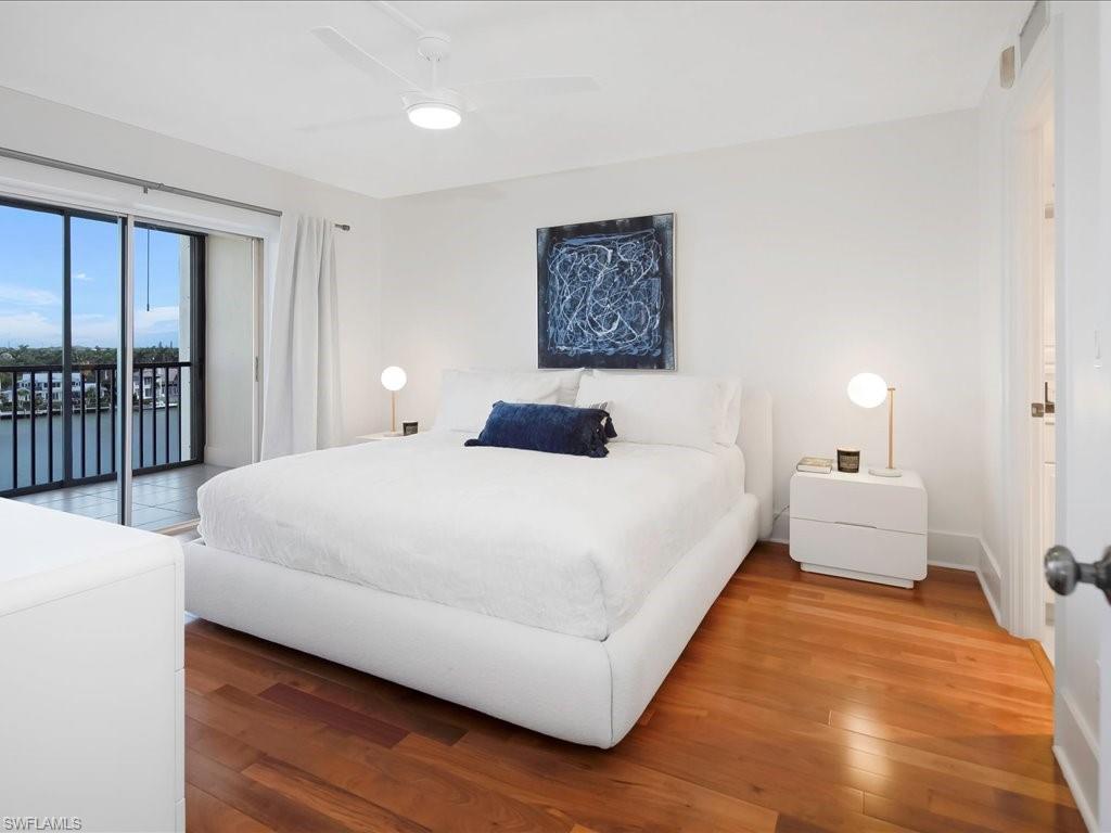 Bedroom featuring access to exterior, wood finished floors, and a ceiling fan