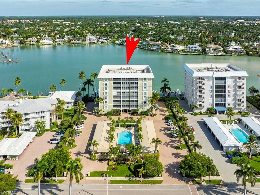 Aerial view of a pool and a nearby body of water