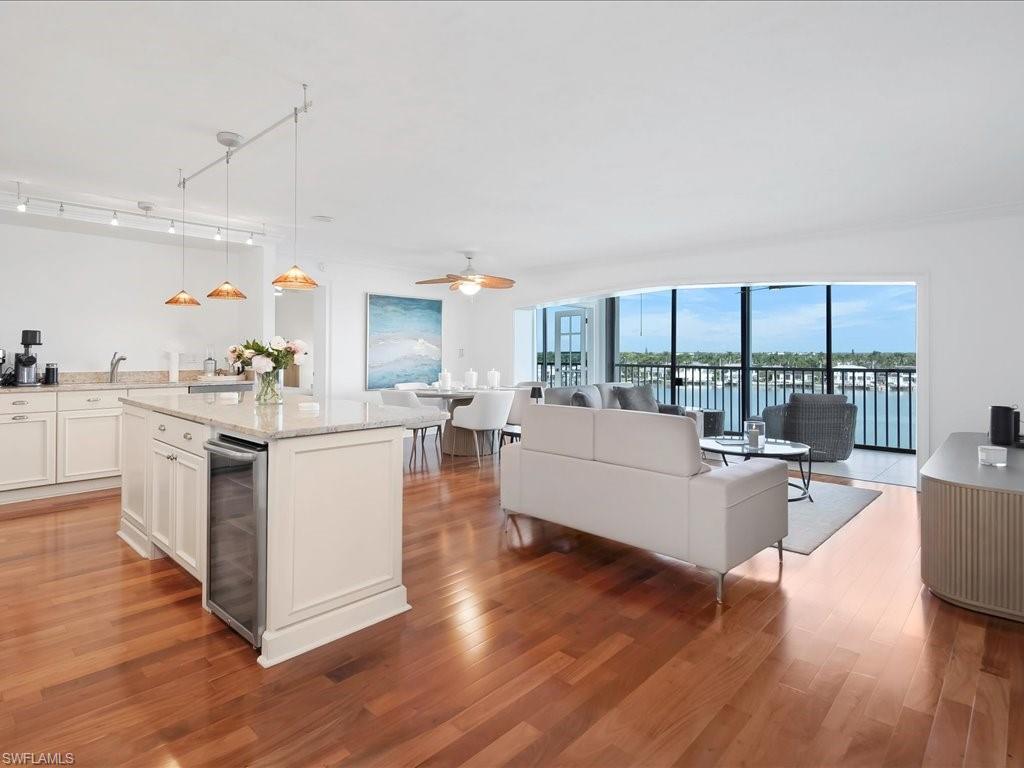Kitchen featuring open floor plan, pendant lighting, light wood-type flooring, and light stone counters