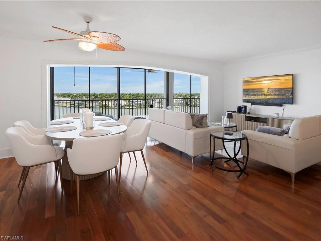 Dining area featuring wood finished floors, crown molding, and a water view