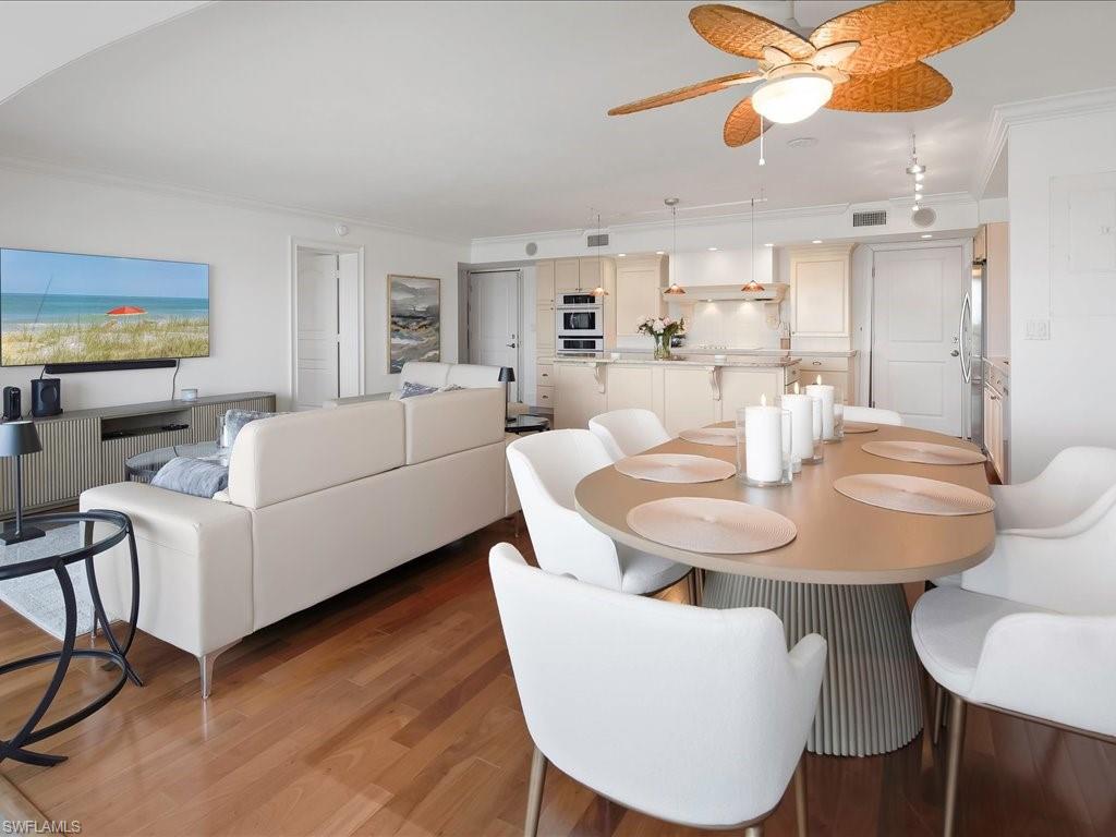 Dining space with ornamental molding, ceiling fan, and wood finished floors