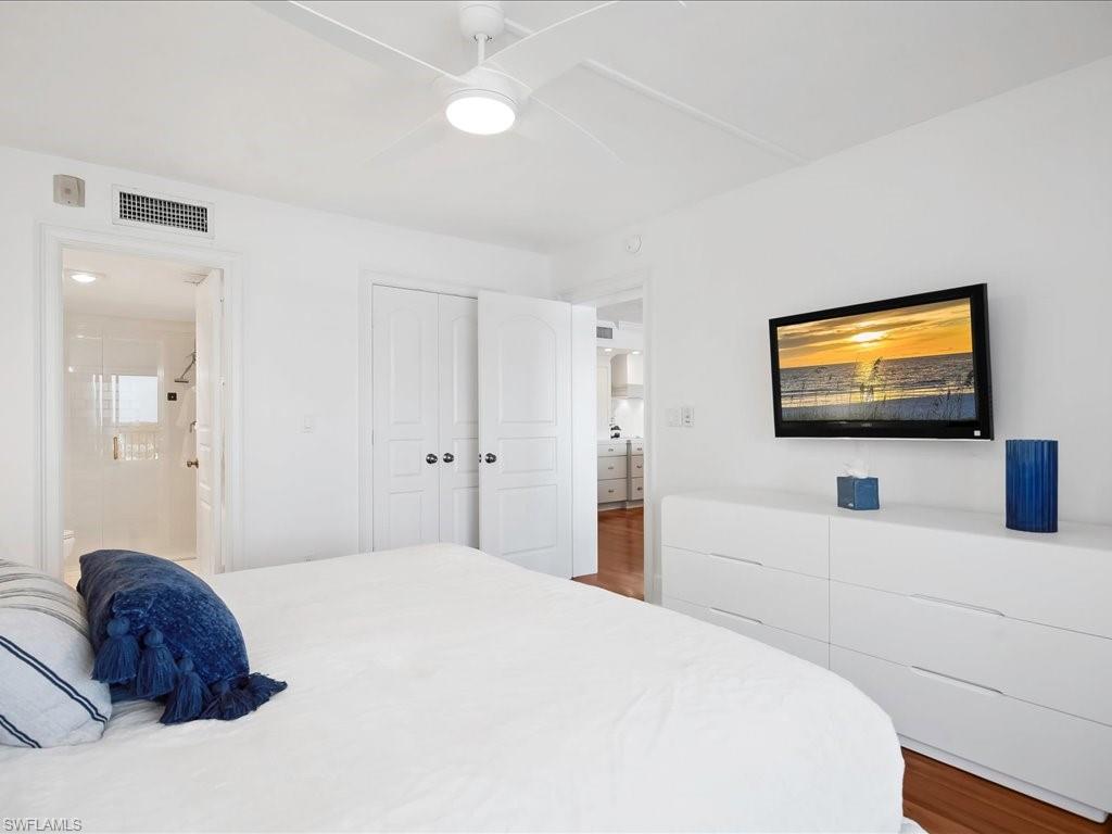Bedroom with wood finished floors, a ceiling fan, and a closet