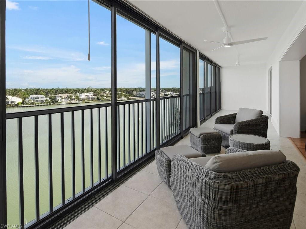 Balcony featuring a water view and a ceiling fan