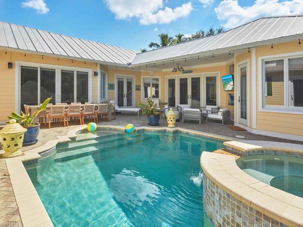 View of swimming pool with french doors, a pool with connected hot tub, and a patio