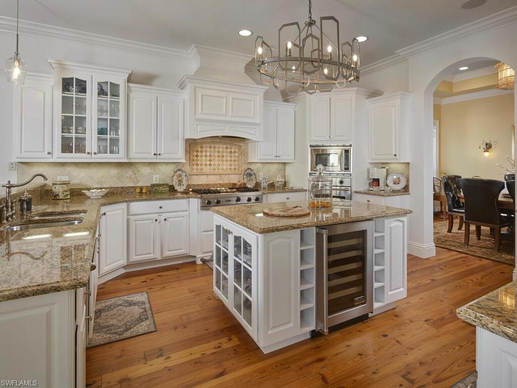 Kitchen featuring glass insert cabinets, open shelves, white cabinets, dark stone counters, and ornamental molding