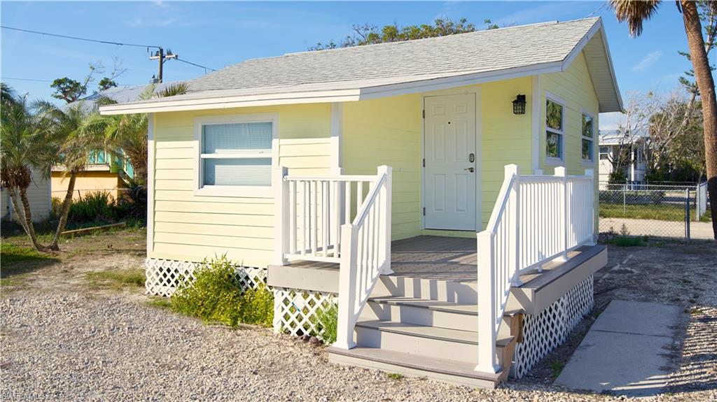 View of front of house with a shingled roof and a deck