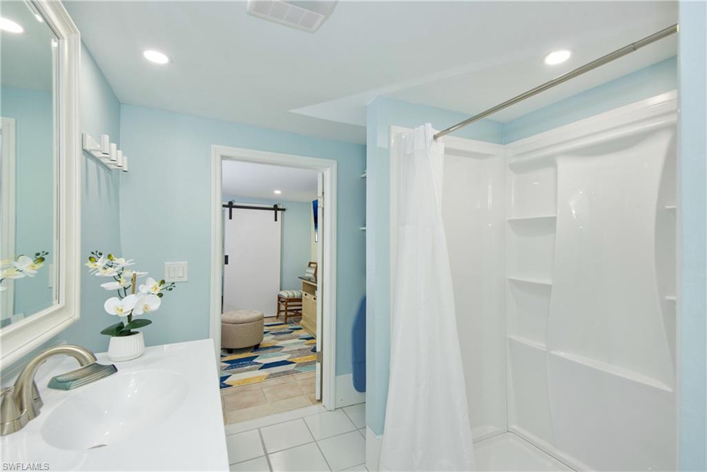 Bathroom featuring recessed lighting, light tile patterned floors, vanity, and a shower with curtain - Virtually Edited Image