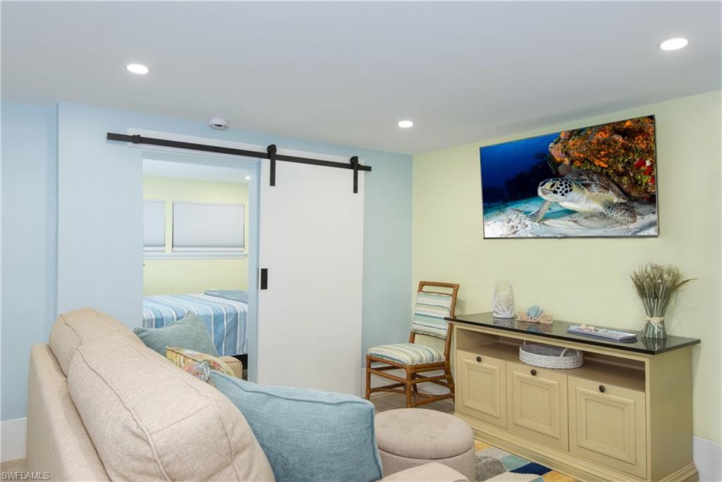 Living area with a barn door and recessed lighting - Virtually Edited Image