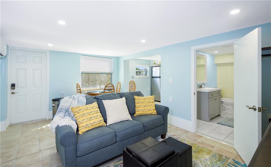 Living room with light tile patterned floors and recessed lighting - Virtually Edited Image