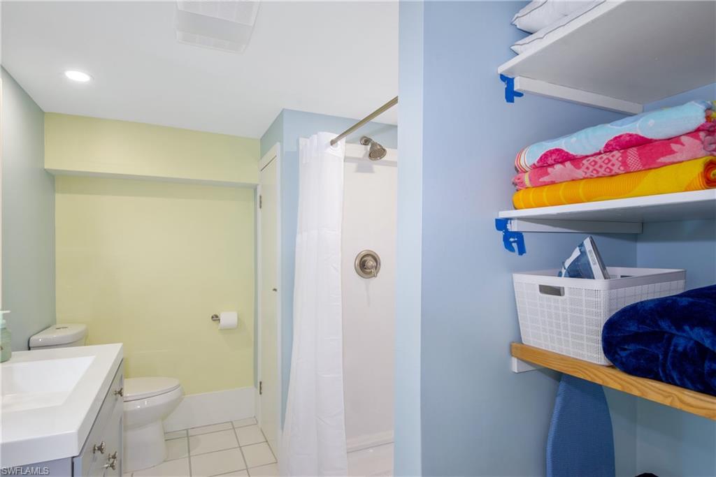 Bathroom featuring light tile patterned flooring, a shower stall, vanity, and recessed lighting - Virtually Edited Image