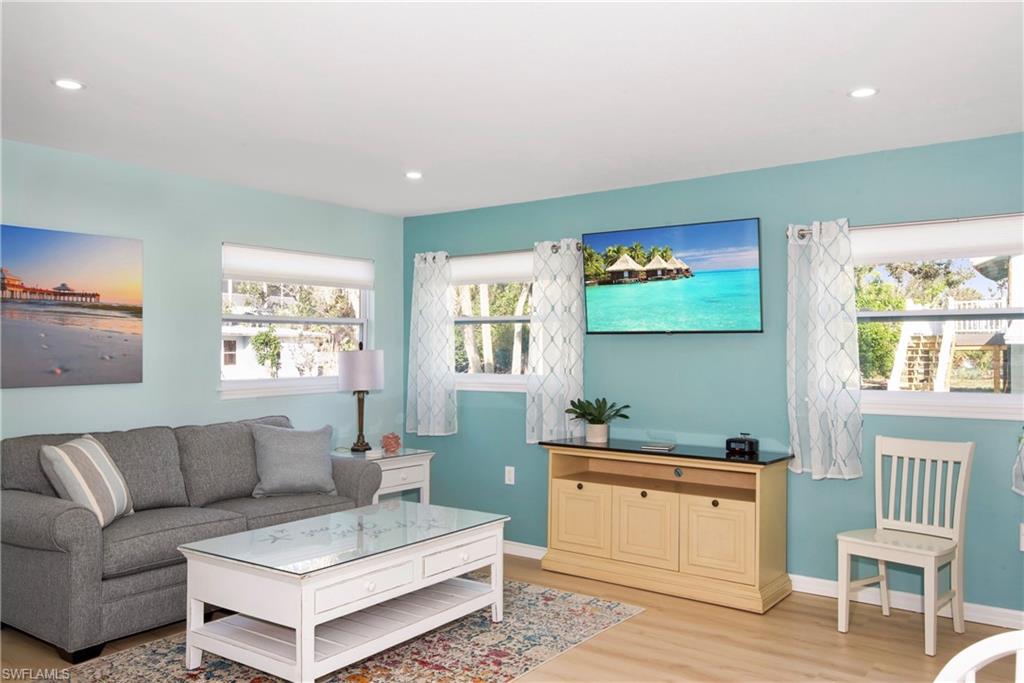 Living room featuring light wood-style flooring and recessed lighting - Virtually Edited Image