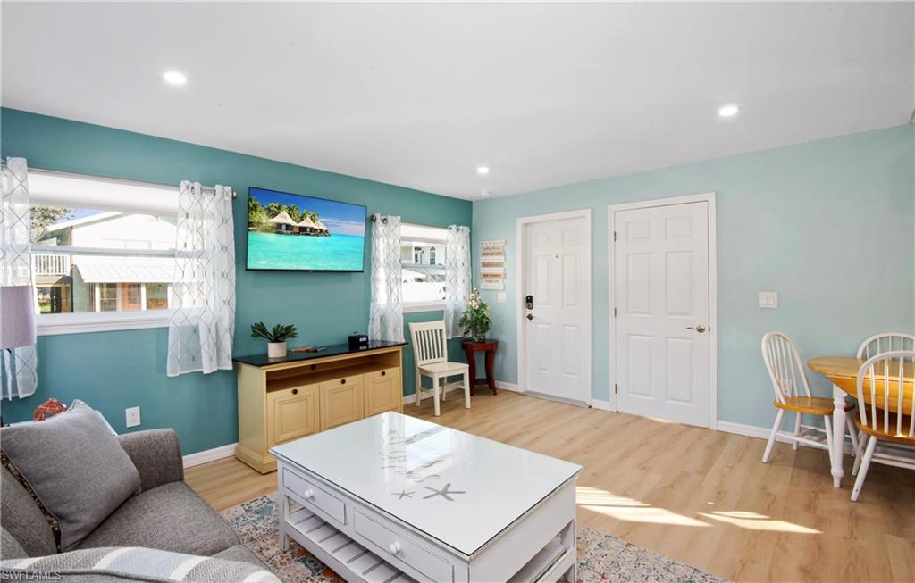 Living area with light wood finished floors and recessed lighting - Virtually Edited Image