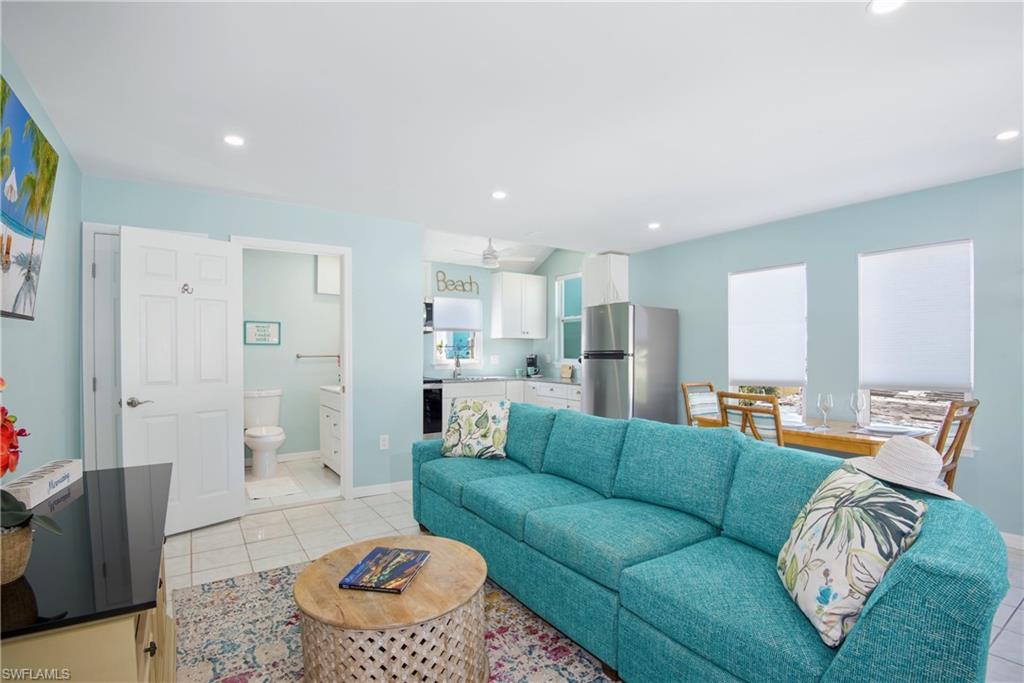 Living room with light tile patterned floors and recessed lighting - Virtually Edited Image