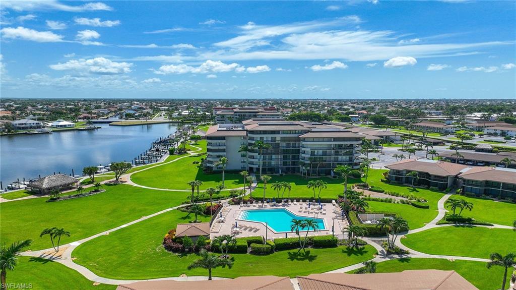 Aerial view of a pool area and a large body of water