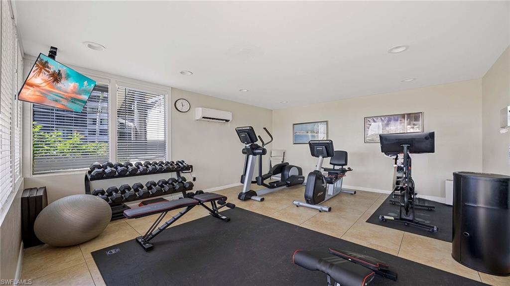 Exercise room with light tile patterned floors and recessed lighting