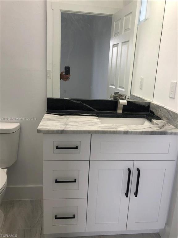 Half bathroom with vanity and toilet